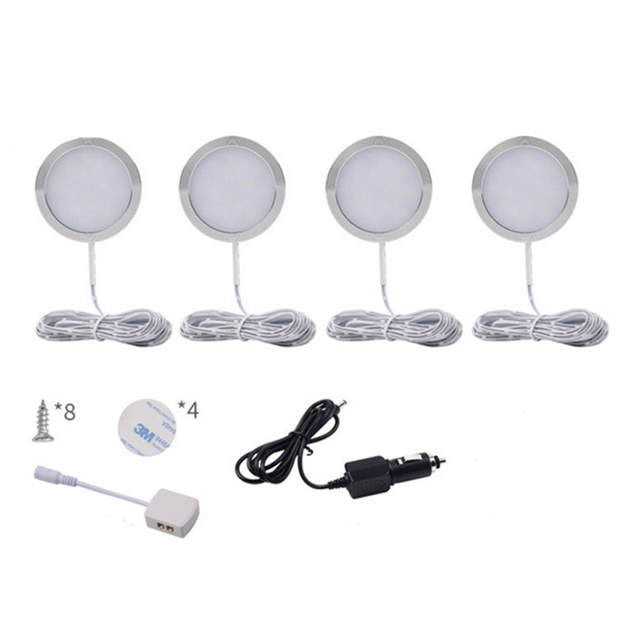 Set of four round LED puck lights with mounting hardware on a white background