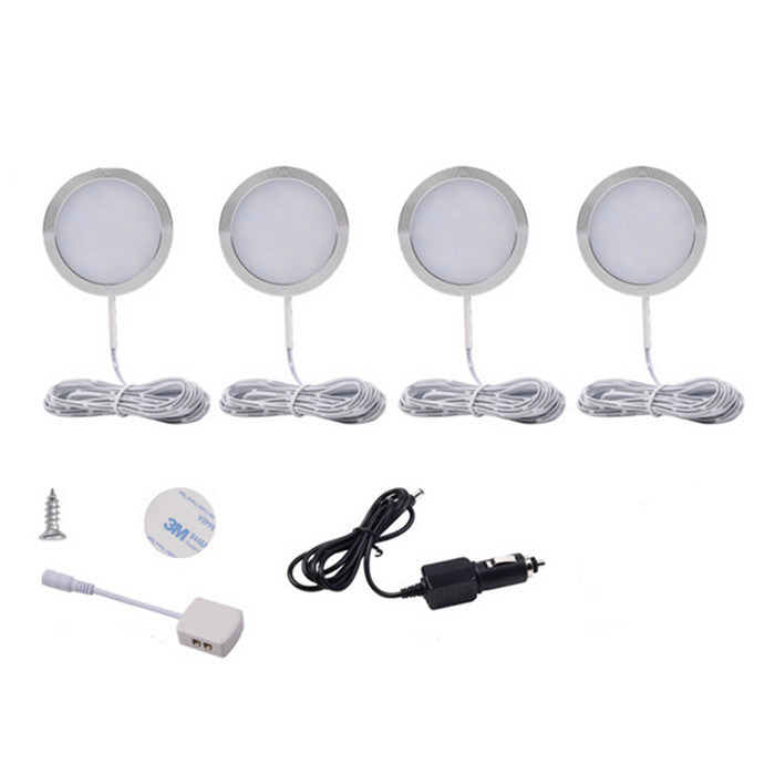 Set of four round LED puck lights with mounting hardware on a white background