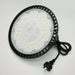 Round industrial light fixture with black casing and visible wiring on a white background
