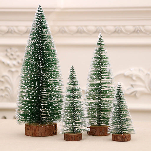 Set of four miniature Christmas trees with wooden bases on a neutral background