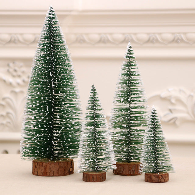 Set of four miniature Christmas trees with wooden bases on a neutral background