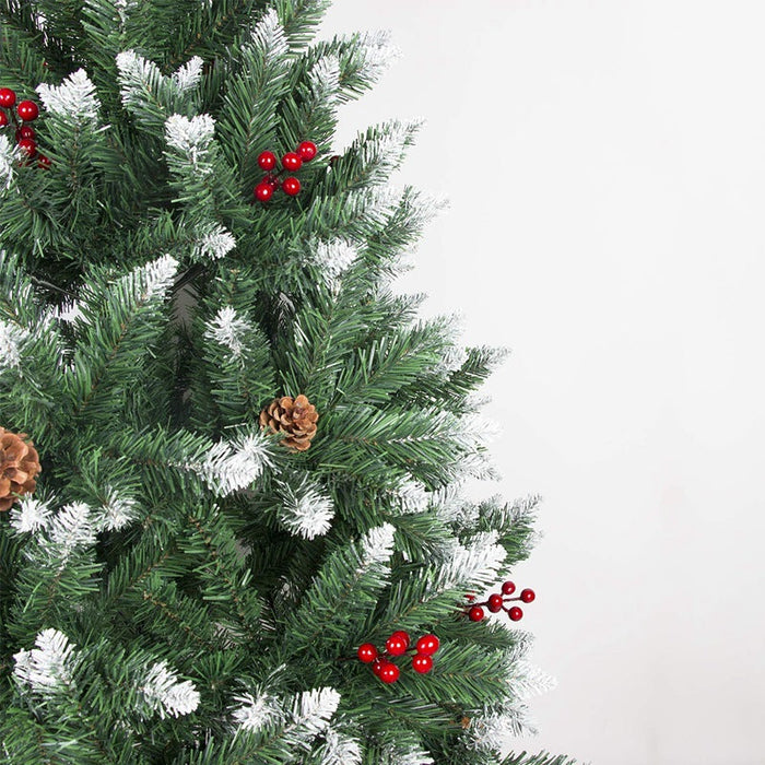 Decorative Christmas tree with green branches, red berries, and pinecones on a white background