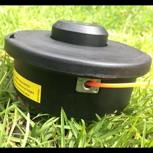 Black lawn mower head on grass