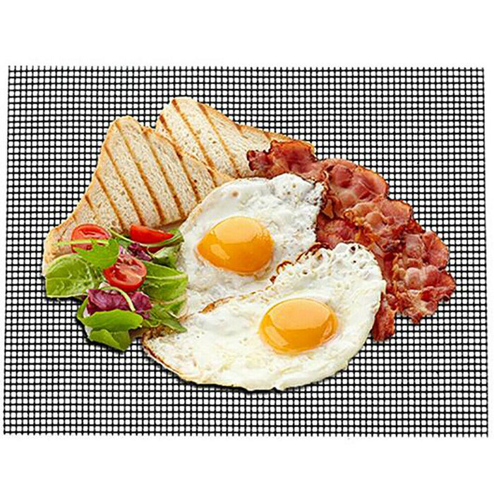 Breakfast setting with eggs, bacon, toast, and salad on a black mesh mat.