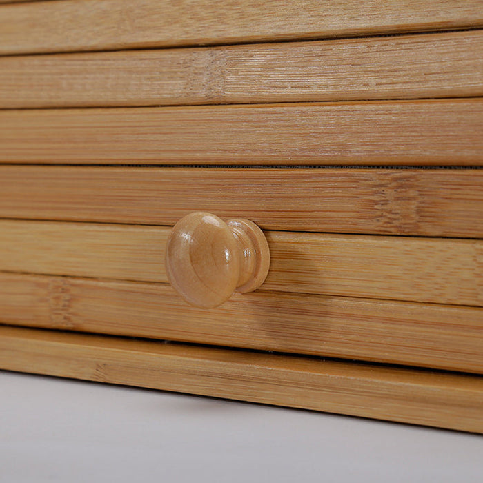Close-up of a wooden drawer with a knob on a light gray background