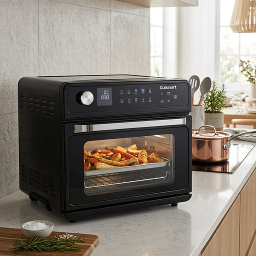 A black Cuisinart countertop combi oven sitting on a white marble kitchen counter.