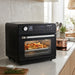 A black Cuisinart countertop combi oven sitting on a white marble kitchen counter.