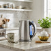 Steaming Cuisinart kettle and tea set in a modern kitchen.