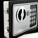 Close-up of a digital safe lock with keypad on a black background
