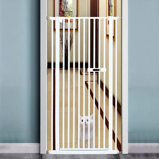 White pet gate in a room with a cat peeking through