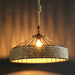 Woven pendant light with a warm glow against a dark background