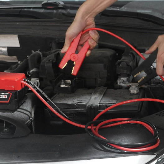 Person using a jump starter to charge a car battery