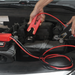 Person using a jump starter to charge a car battery