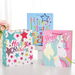 A set of three gift bags with 'Happy Birthday' and sparkling glitter designs, featuring different colors and one with a unicorn illustration.