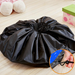 Black drawstring bag on a wooden floor with a close-up of the drawstring.