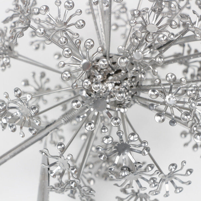 Close-up of a metallic snowflake ornament on a light gray background