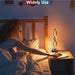 Person lying in bed  next to a nightstand with a decorative lamp.
