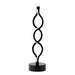 A modern black metal table lamp with a circular base and a vertical, twisting spiral design resembling three stacked teardrop loops, shown against a plain white background.