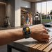 Black smartwatch worn on a wrist in a modern gym setting.