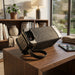 Black portable speaker with textured surface and control buttons 
