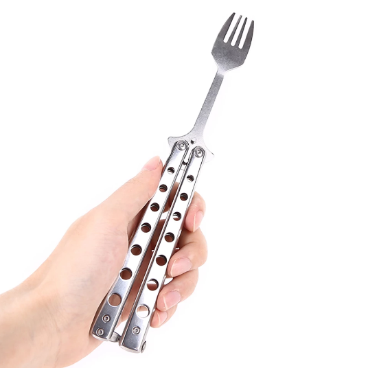 Hand holding a metal folding fork on a white background