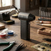 Titan 130,000 RPM Ultra High-Speed Turbo Fan Blower and Air Duster in matte black with control buttons and angled nozzle.