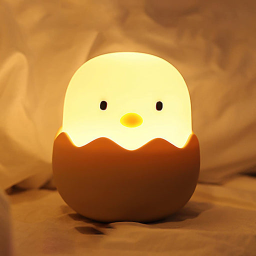 Cute chick-shaped night light with a soft glow on a beige background