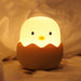 Cute chick-shaped night light with a soft glow on a beige background