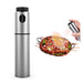 A stainless steel olive oil spray bottle with a depiction of its use, showing oil being sprayed onto food.