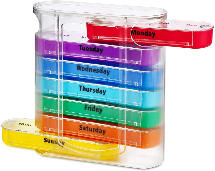 A clear plastic, stacked, weekly pill organizer with seven colorful daily trays (Monday through Sunday). The red 'Monday' tray is partially pulled out from the top, and the yellow 'Sunday' tray is partially pulled out from the bottom. Each tray is a different color and labeled with the day of the week in black text.