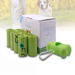 A box labeled 'Eco Friendly' containing 20 rolls of biodegradable pet poop bags, with a green plastic dispenser and several bags visible in the foreground.