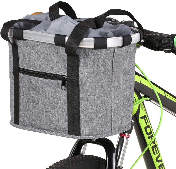 A gray bike storage basket with a woven canvas construction, attached to a bicycle handlebar. The basket has black straps and a silver aluminum frame.