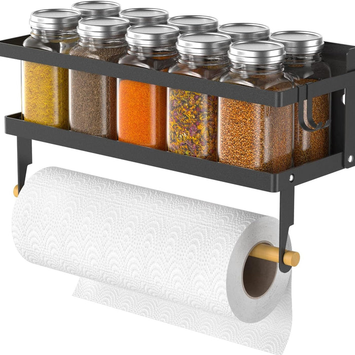 A black magnetic spice rack with hooks attached to a refrigerator, holding several spice jars and a roll of paper towel.