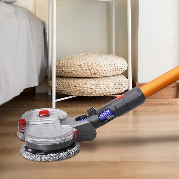A product image shows a gray and clear motorized mop head attachment on an orange stick vacuum pole, cleaning a wooden floor near a bed. The low-profile design with two spinning pads and red accents is visible, emphasizing its ability to clean under furniture.