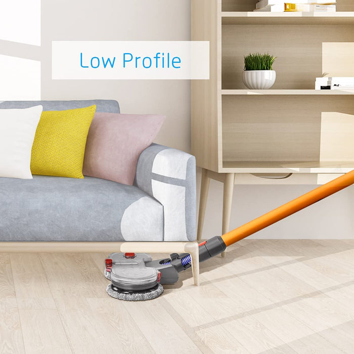 A product demonstration image showing a gray and clear motorized mop head attachment connected to an orange stick vacuum pole, cleaning the light wooden floor underneath a light gray sofa. Text overlay reads: "Low Profile," highlighting the mop head's slim design for cleaning hard-to-reach areas.