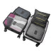 An open black rolling suitcase is efficiently organized with a set of travel packing cubes and laundry pouches. The cubes are packed with folded clothing and the right side holds three stacked black flat laundry pouches and a large patterned cube, showcasing a complete luggage organizer system.
