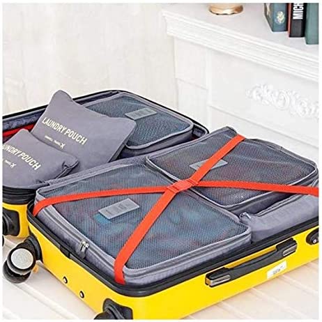 An open, yellow rolling suitcase is organized with gray travel packing cubes and laundry pouches. The main section has two large mesh-top cubes secured by an orange strap, while the lid compartment holds smaller cubes and a flat "LAUNDRY POUCH."