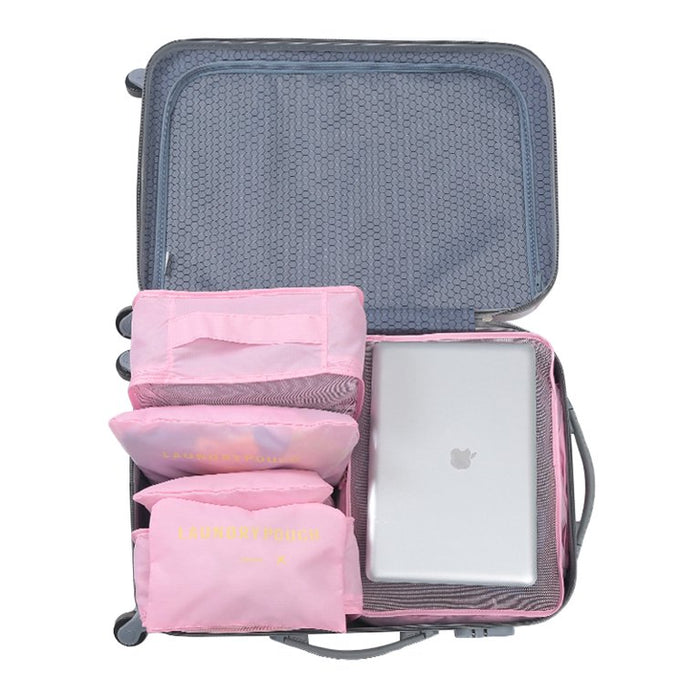 
An open suitcase shows a set of pink travel packing cubes organized on one side, leaving space for a silver laptop or tablet. The bags consist of two small mesh cubes and two flat "LAUNDRY POUCH" bags stacked vertically, demonstrating the efficient use of the luggage organizer set.